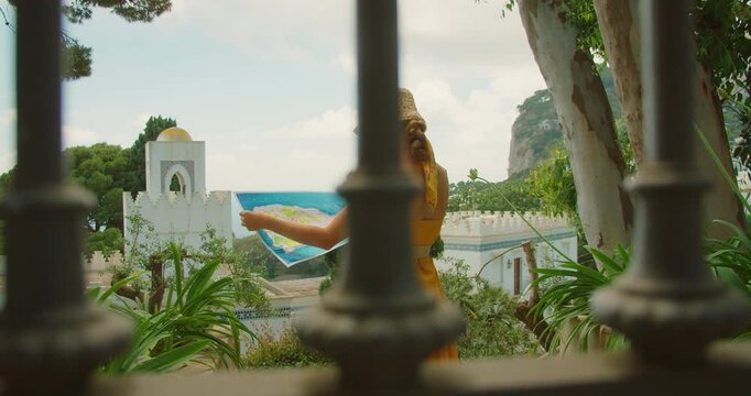 Woman studying island map above gardens with architecture and sea view in Capri