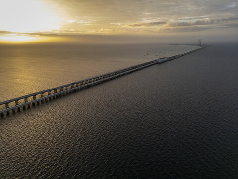 Aerial view of the long Puerto Progreso pier stretching into the Gulf of Mexico at sunset, with calm waters and golden light reflecting on the surface in Progreso, Yucatan, Mexico.