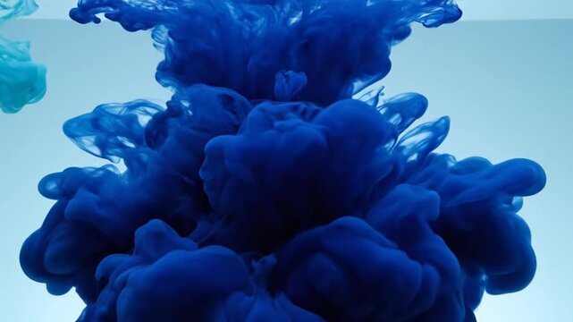 Blue ink cloud swirling in clear water