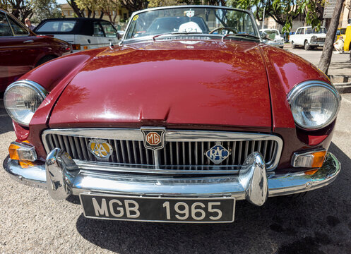 TAVERNES BLANQUES, SPAIN - JUNE 14, 2026.Classic red MG MGB roadster sports car on display with chrome bumper and custom license plate at a car show location in the afternoon