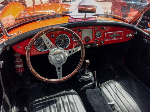 TAVERNES BLANQUES, SPAIN - JUNE 14, 2026.Interior view of classic red MG MGA roadster with wooden steering wheel and leather seats in car show setting
