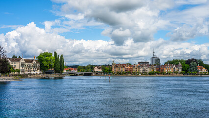 Fototapeta premium View of Konstanz from the opposite shore of Lake Constance with buildings along the water and clouds in the sky