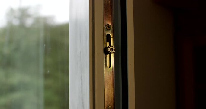 Close-up view of an open window showing the metal locking mechanism inside the wooden frame