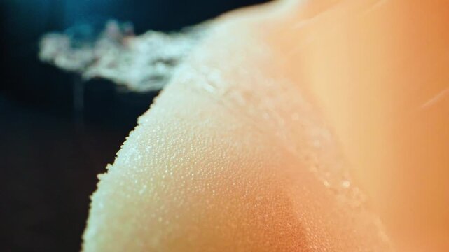 Macro view of a spray gun applying glue to a polyurethane foam surface. Upholstery and furniture making process in a factory setting