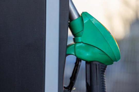 Green Diesel Fuel Pump Nozzle Hanging in Fuel Station Dispenser Close Up