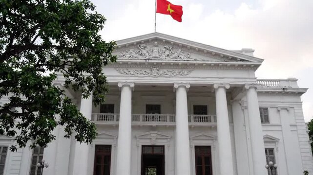 The ho chi minh city peoples committee building with the vietnamese flag flying on top