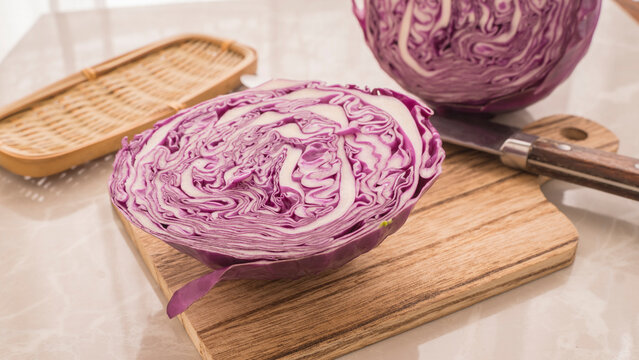 Purple cabbage cut in half on a cutting board. Half a red cabbage on a cutting board