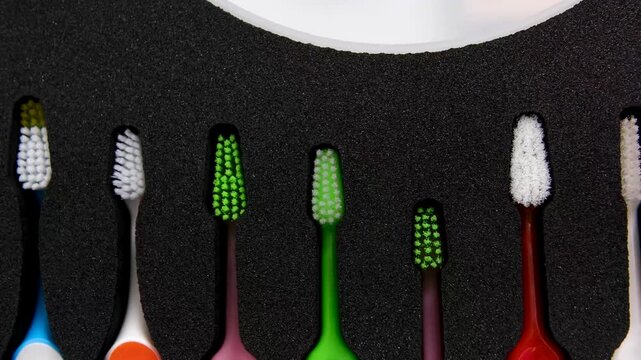 Colorful orthodontic toothbrushes arranged in row for daily oral hygiene and braces care