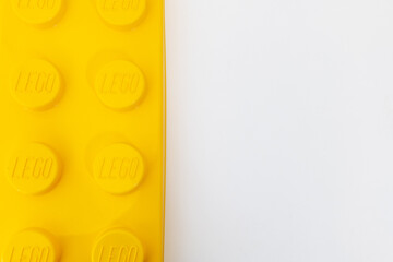 Naklejka premium Bradford, UK June 24 2026 - Close-up of a yellow LEGO storage container lid designed to resemble an ordinary LEGO brick, isolated on a white background with copy space.