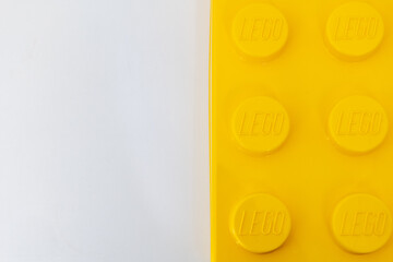 Naklejka premium Bradford, UK June 24 2026 - Close-up of a yellow LEGO storage container lid designed to resemble an ordinary LEGO brick, isolated on a white background with copy space.
