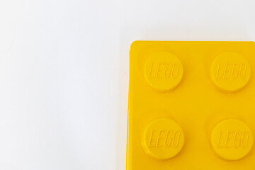 Naklejka premium Bradford, UK June 24 2026 - Close-up of a yellow LEGO storage container lid designed to resemble an ordinary LEGO brick, isolated on a white background with copy space.