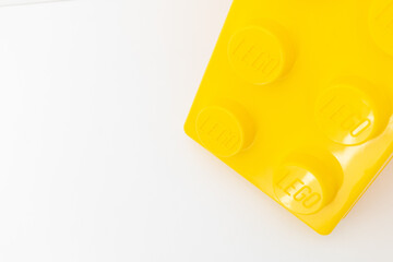 Naklejka premium Bradford, UK June 24 2026 - Close-up of a yellow LEGO storage container lid designed to resemble an ordinary LEGO brick, isolated on a white background with copy space.