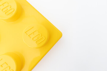 Naklejka premium Bradford, UK June 24 2026 - Close-up of a yellow LEGO storage container lid designed to resemble an ordinary LEGO brick, isolated on a white background with copy space.