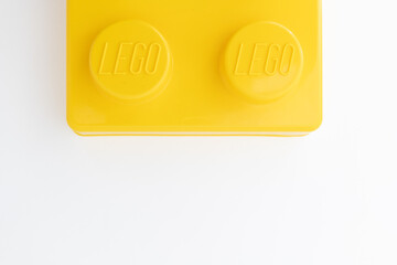 Naklejka premium Bradford, UK June 24 2026 - Close-up of a yellow LEGO storage container lid designed to resemble an ordinary LEGO brick, isolated on a white background with copy space.