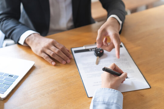 Business car rent, sell service, hand of agent dealer, male giving auto key of vehicle to customer after sign on lease paperwork, document contract with buyer young woman client transfer automobile.