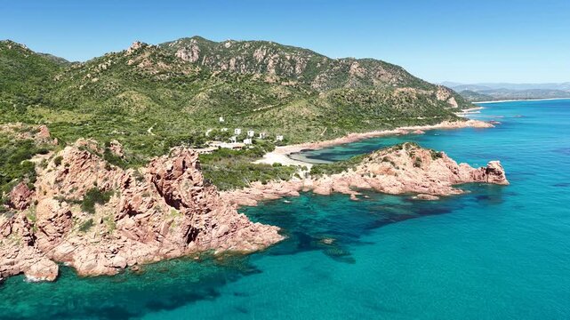 4K drone flight along the Marina di Gairo coastline, featuring Su Sirboni Beach and Cala Laus. Turquoise waters, striking red rocks, and the unspoiled beauty of Sardinia, Italy