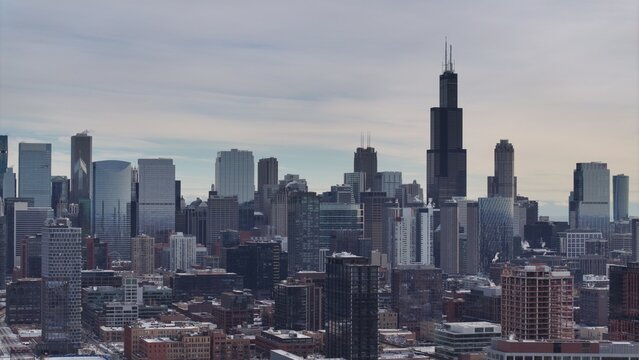 Aerial view of the Chicago skyline featuring the Willis Tower, dense urban architecture, and skyscrapers under a cloudy sky in Chicago, Illinois, United States.