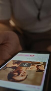 Vertical video of Caucasian young adult man swiping right on female profile on dating application on smartphone and getting love match. Online dating services and mobile app marketing