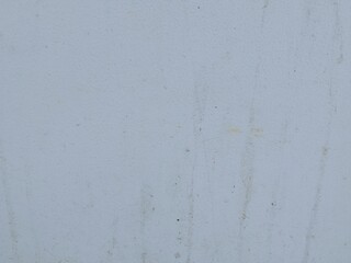 Fototapeta premium A weathered white wall texture featuring subtle dirt marks, stains, and natural surface imperfections. The minimalist background offers a neutral and versatile design element suitable for construction