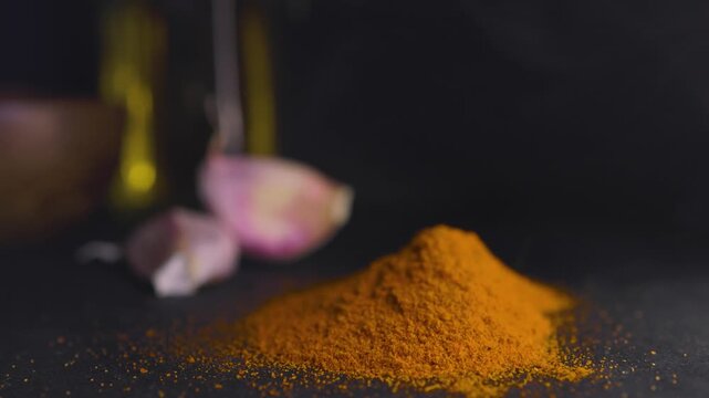 Red parika in the process of smoking with condiments in blurred background.Promotional graphic resource for spices and food.Concept of smoked spices and flavours. Spices and food promotion.