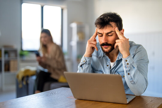 Digital nomad business man analyzes work on his laptop, tackling stressful tasks and tight deadlines