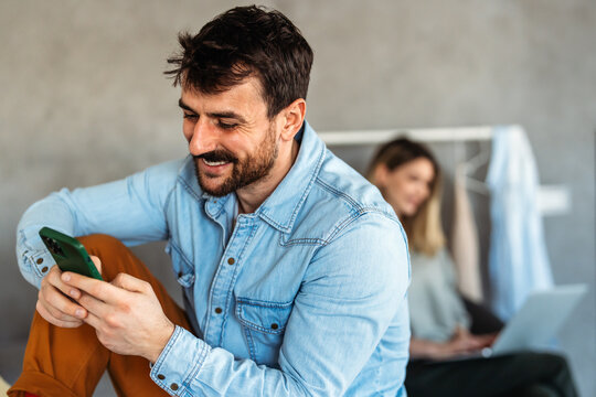 Young man using cellphone for work, social media or relaxation. Smart phone people concept.