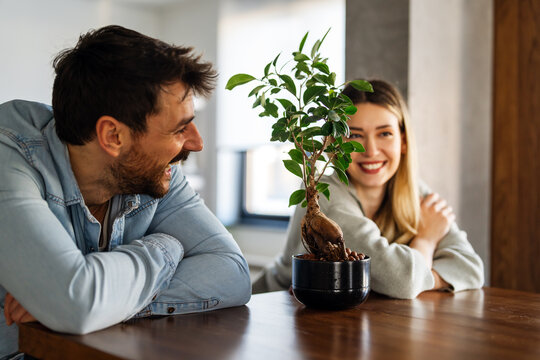 Plant care. Nature protection concept. Smiling environmentally friendly couple with houseplants