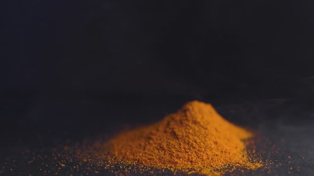 Horizontal view of pile of red parika in the process of smoking.Concept of smoked spices and flavours.Promotional graphic resource for spices and food.Spices and mexican or asian food promotion.