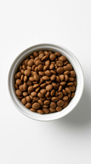 Fototapeta premium Bowl of dry cat food kibble viewed from above on a clean white background, representing balanced feline nutrition and healthy pet feeding.