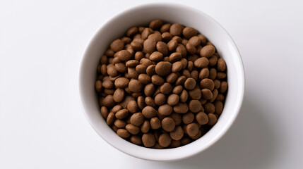 Fototapeta premium Bowl of dry cat food kibble viewed from above on a clean white background, representing balanced feline nutrition and healthy pet feeding.