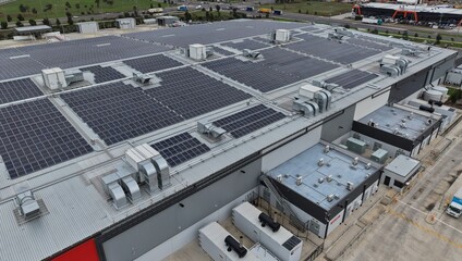 Industrial building rooftops with solar panels generating renewable energy © GoAerials
