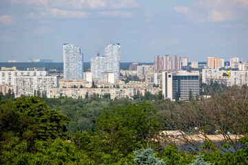 Naklejka premium Kyiv, Ukraine, offers an expansive urban landscape with numerous residential areas along the Dnipro river's left bank, showcasing modern high-rise towers and diverse city structures Includes copy spac