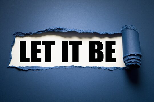 Let it be phrase written on white paper under torn dark blue background