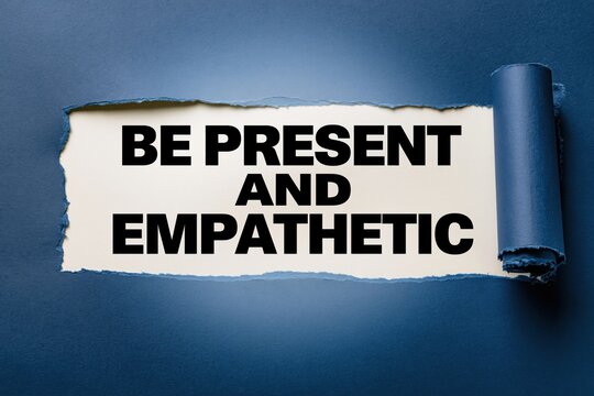 Be present and empathetic concept written under torn blue paper