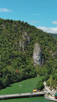 Aerial view of stone carved statue portrait of ancient dacian king Decebal. Sculpture near Danube River, Romania. Vertical video 4k