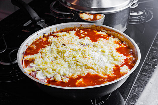 Skillet lasagna with melted cheese cooking in frying pan