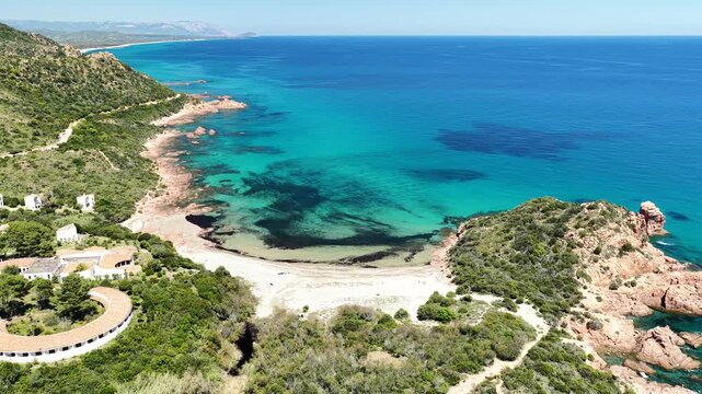 4K drone flight along the Marina di Gairo coastline, featuring Su Sirboni Beach and Cala Laus. Turquoise waters, striking red rocks, and the unspoiled beauty of Sardinia, Italy