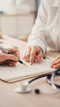 Patient signs papers under the guidance of a medical practitioner