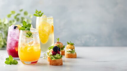 Fototapeta premium Colorful citrus and berry mocktails with finger food on soft gray background for promotional banner and summer party design