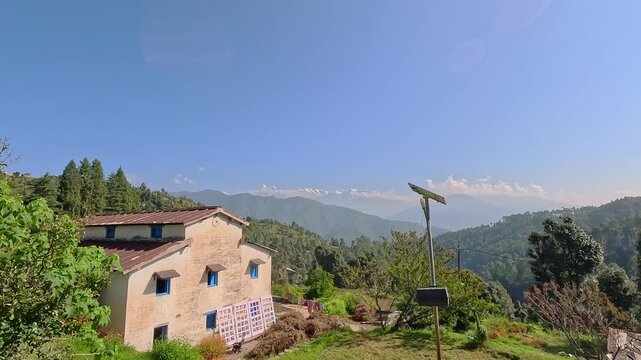 Scenic rural village house in the Garhwal Himalayas of Uttarakhand, India, with a panoramic mountain view.
