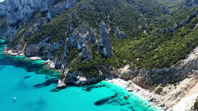 4K drone footage of Goloritz&egrave; Beach on the Baunei coast, Gulf of Orosei, Sardinia. Crystal-clear turquoise waters, white limestone cliffs, and one of Italy&rsquo;s most iconic seascapes