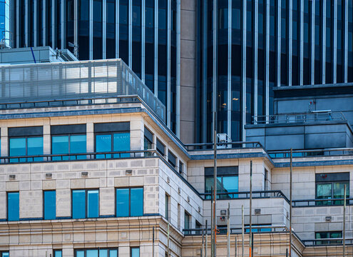 A mixture of modern and old building architectural styles, featuring a stone facade alongside a blue-glass tower.