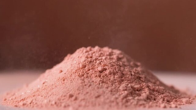 Slow Motion Time-Lapse of Finely Milled Pink Cosmetic Powder Being Puffed, Cinematic 1080p Beauty and Makeup Background
