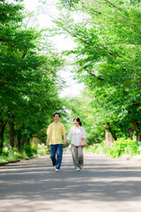 Fototapeta premium 初夏の公園を散歩するカップル 