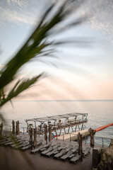 Fototapeta premium Sea terrace with sun loungers at sunset