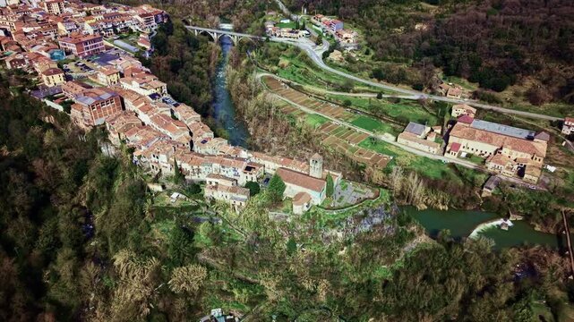 Aerial view of Castellfollit de la Roca village surrounded by mountains and green valley