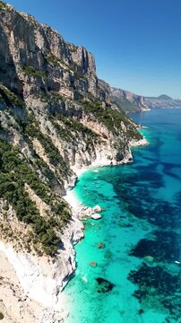 4K drone footage of Goloritz&egrave; Beach on the Baunei coast, Gulf of Orosei, Sardinia. Crystal-clear turquoise waters, white limestone cliffs, and one of Italy&rsquo;s most iconic seascapes