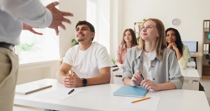 Students listening to teacher in classroom. College students focus on learning during an interactive lesson that promotes education and open discussion. Clear concept of active higher education.