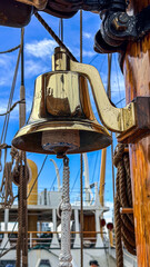 Ship bell on a sailing vessel at a port during the day © Creative house