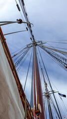 Fototapeta premium Tall ship masts reach towards the sky during a sailing trip on a clear day